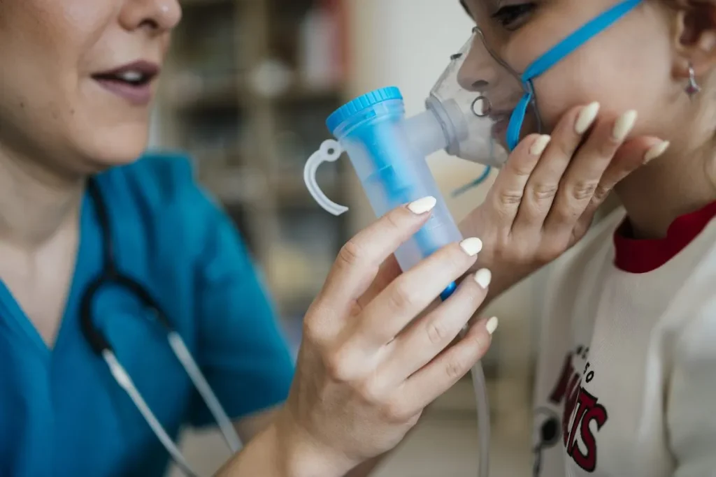 3840px Child receiving breathing treatment from healthcare professional in a medical setting during daytime undefined