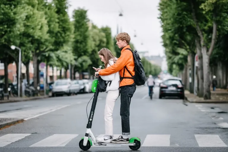 Panama’s Electric Scooter License Plan Has 1 Big Flaw girl on her phone while the guy drives an electric scooter. By Kristoffer Trolle from Copenhagen, Denmark - Generation Z kids on Electric Scooter, CC BY 2.0, https://commons.wikimedia.org/w/index.php?curid=83380626